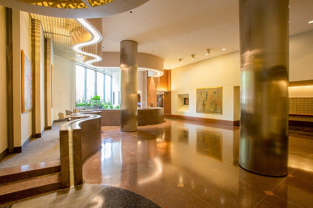 the lobby of a building with columns and a large window