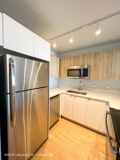 a modern kitchen with stainless steel appliances and white cabinets