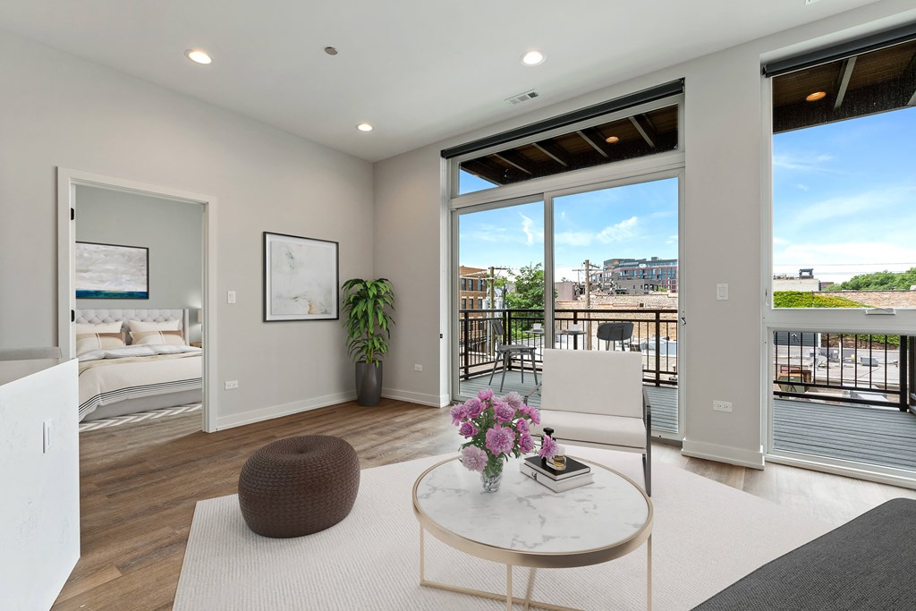 a living room with a large window and a door that leads to a balcony