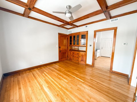 A room with wooden floors and a ceiling fan.