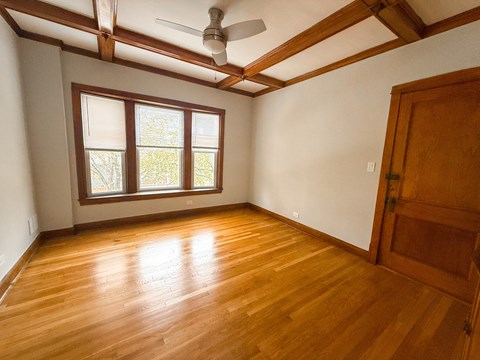 A room with wooden floors and a ceiling fan.