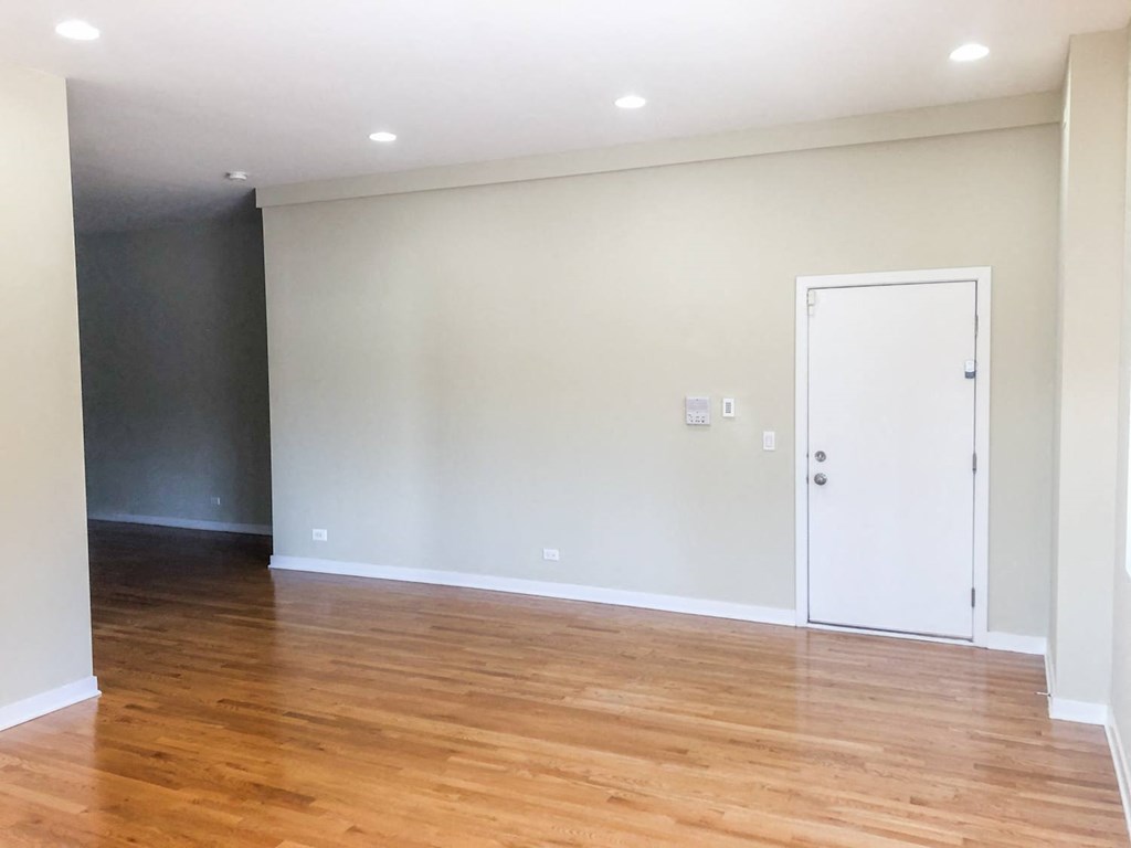 a living room with white walls and wood floors
