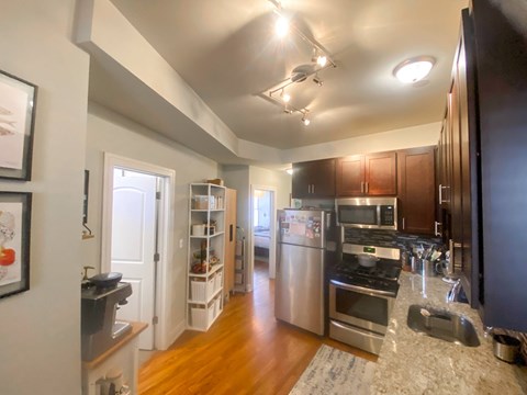 A kitchen with a refrigerator, oven, and microwave.