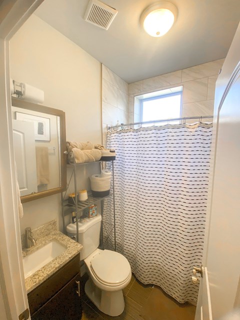 A white toilet in a bathroom with a shower curtain.