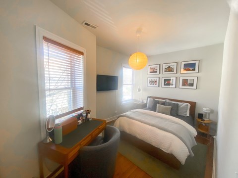 A bedroom with a bed, desk, and chair.