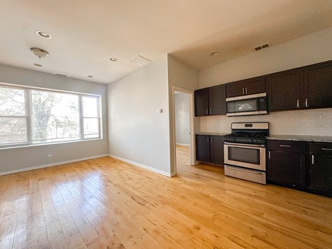 A kitchen with a microwave, oven, and stove top.