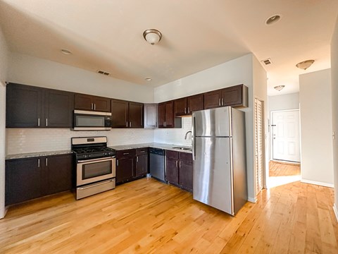 A kitchen with wooden floors and stainless steel appliances.