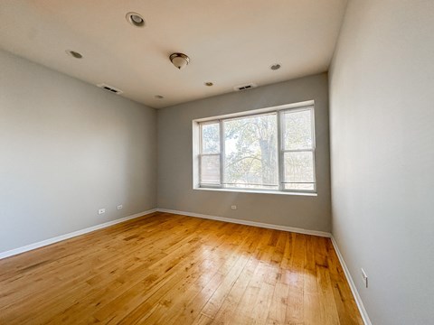 A room with wooden flooring and a window.