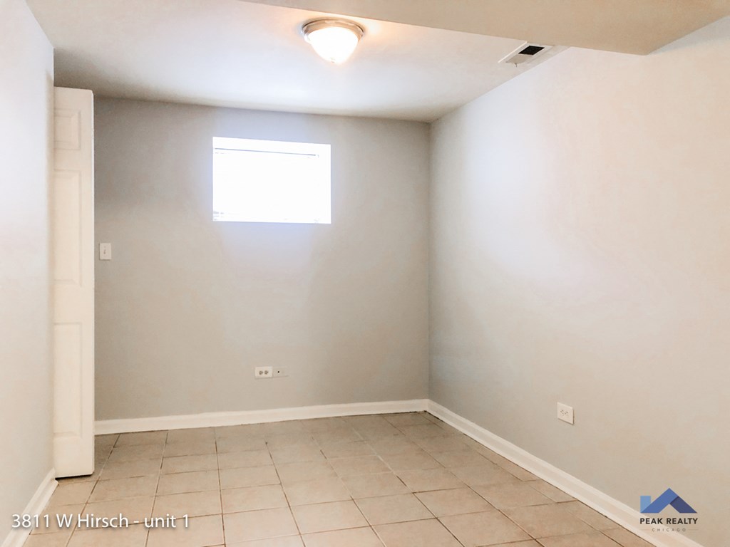 an empty room with white walls and a window