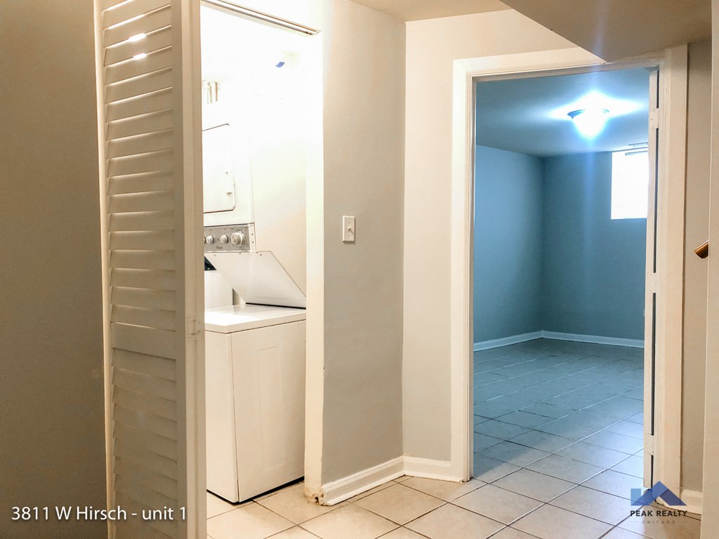 a white kitchen with an open door to a closet
