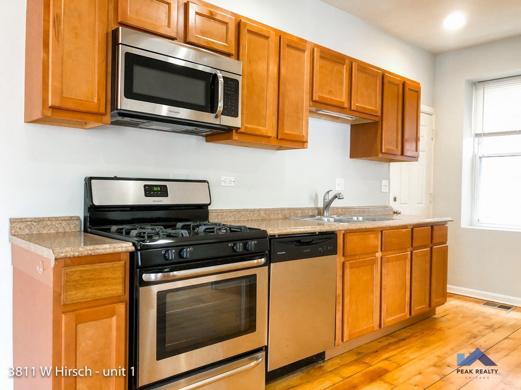 a kitchen with stainless steel appliances and wooden cabinets