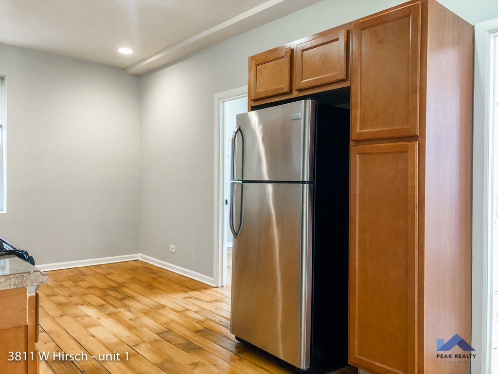 a kitchen with a stainless steel refrigerator and wooden cabinets