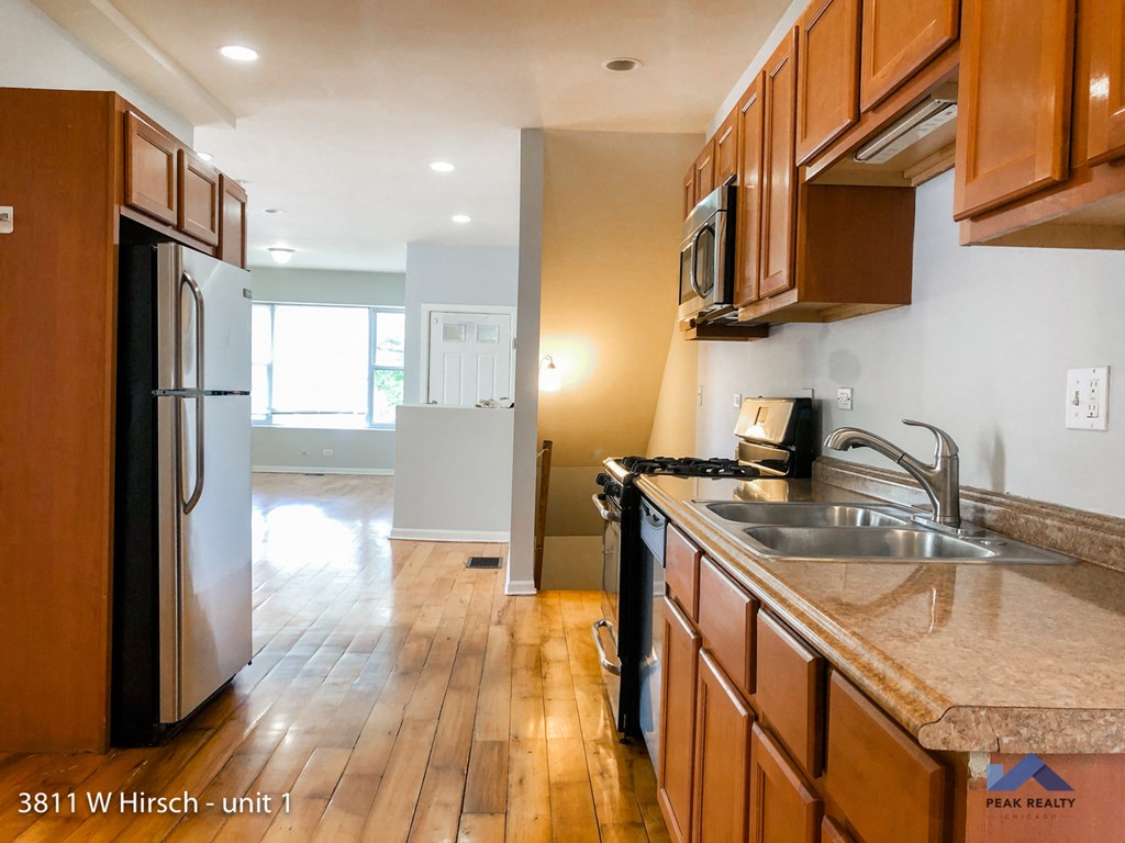 an empty kitchen with wooden cabinets and stainless steel appliances