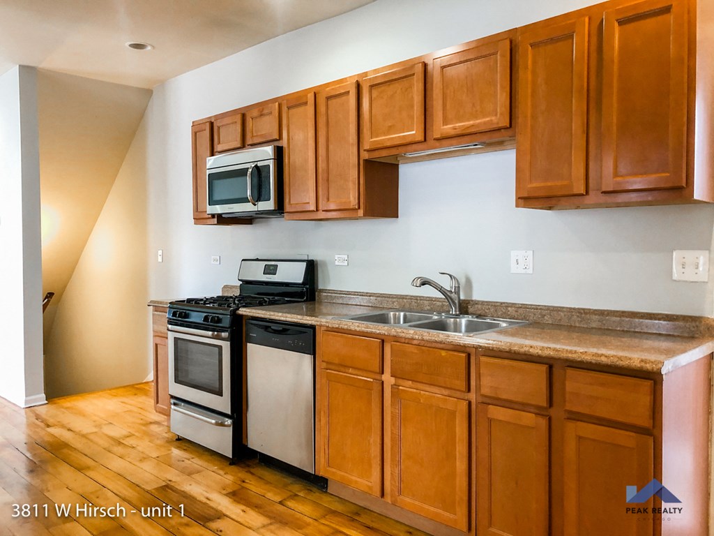 a kitchen with wooden cabinets and a sink and a stove