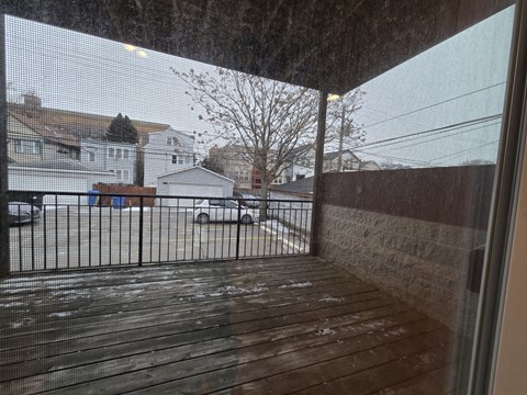 A view from inside a house looking out to a snowy street.