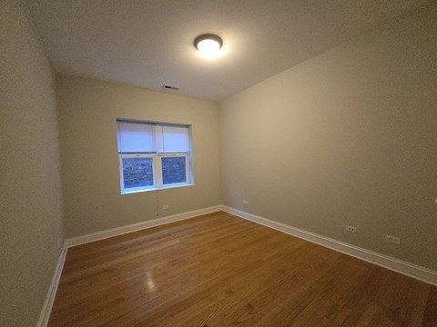 A room with wooden flooring and a window.
