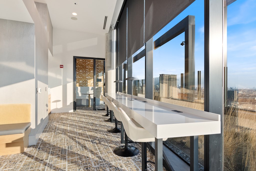 a coworking space with countertop seating available and large windows with views of Chicago