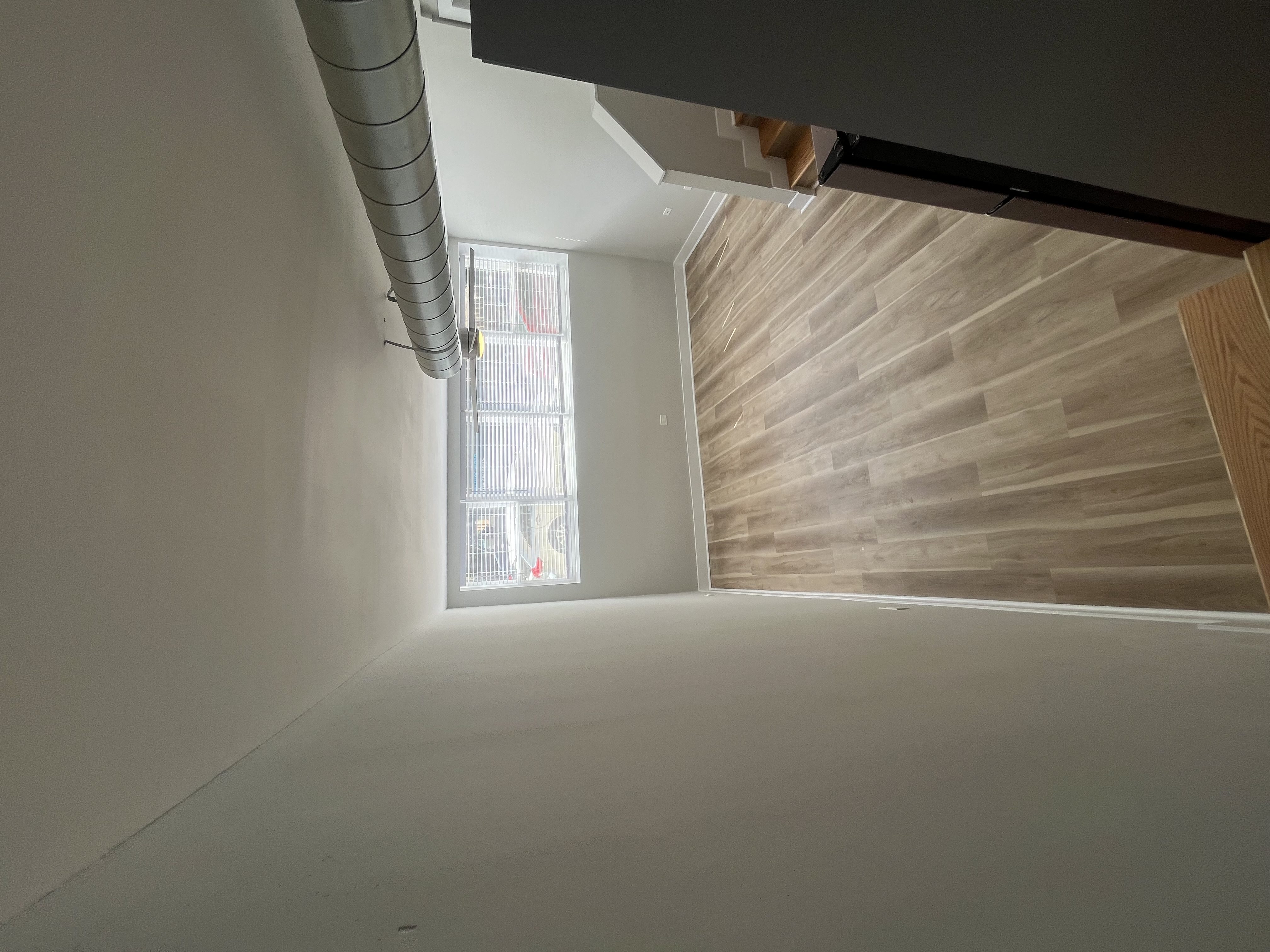 an empty room with a wood wall and a window