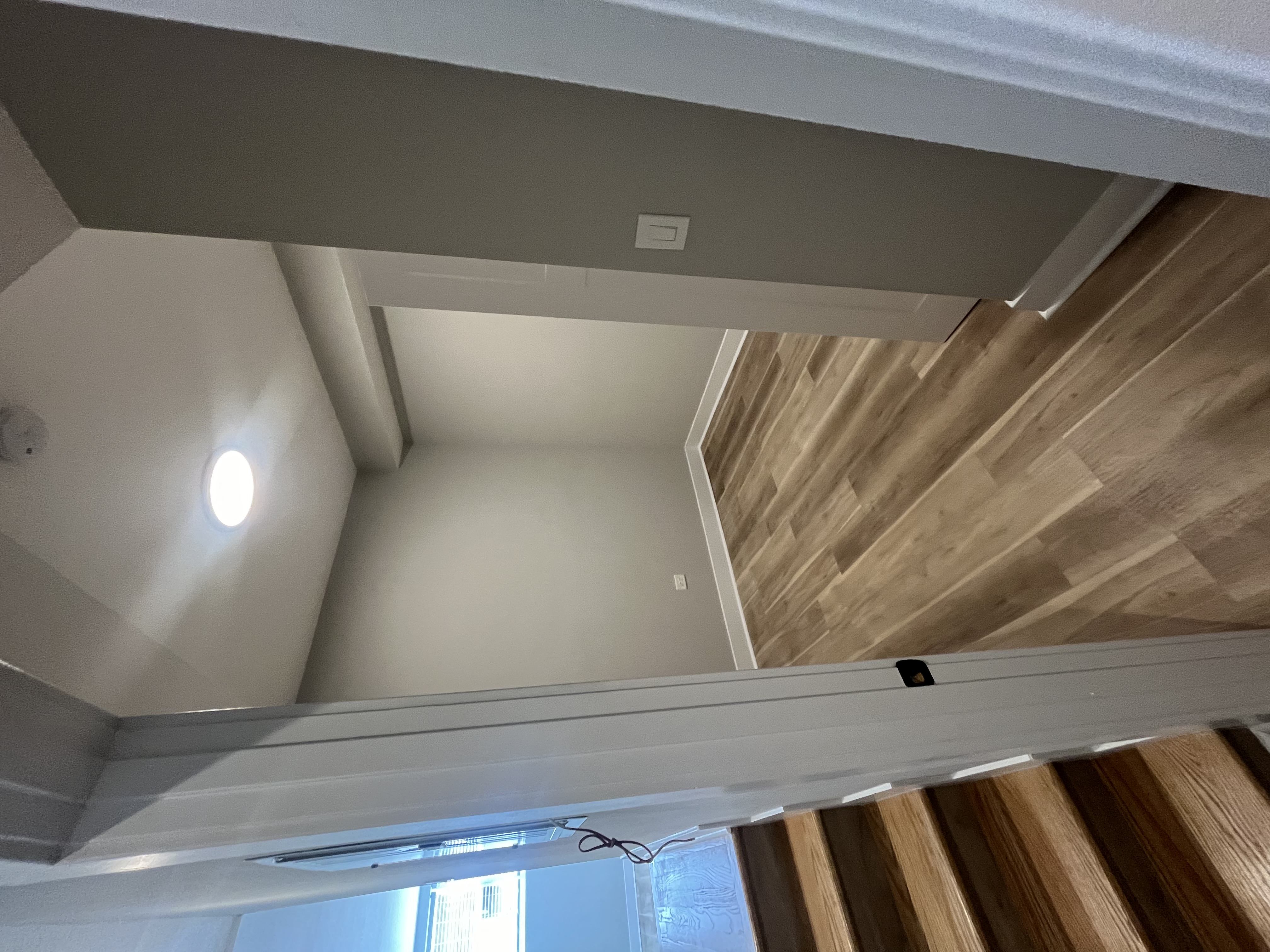 the ceiling in the living room has been painted white and the floor has been installed