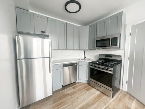 A modern kitchen with a stainless steel refrigerator, oven, and microwave.
