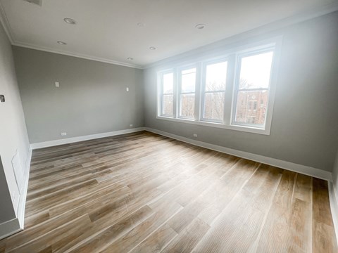 A room with wooden flooring and a window.