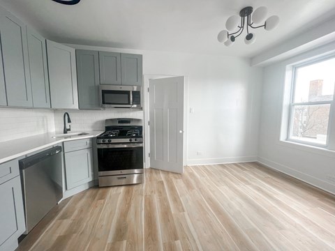 A kitchen with a stove top oven and a microwave above the stove.