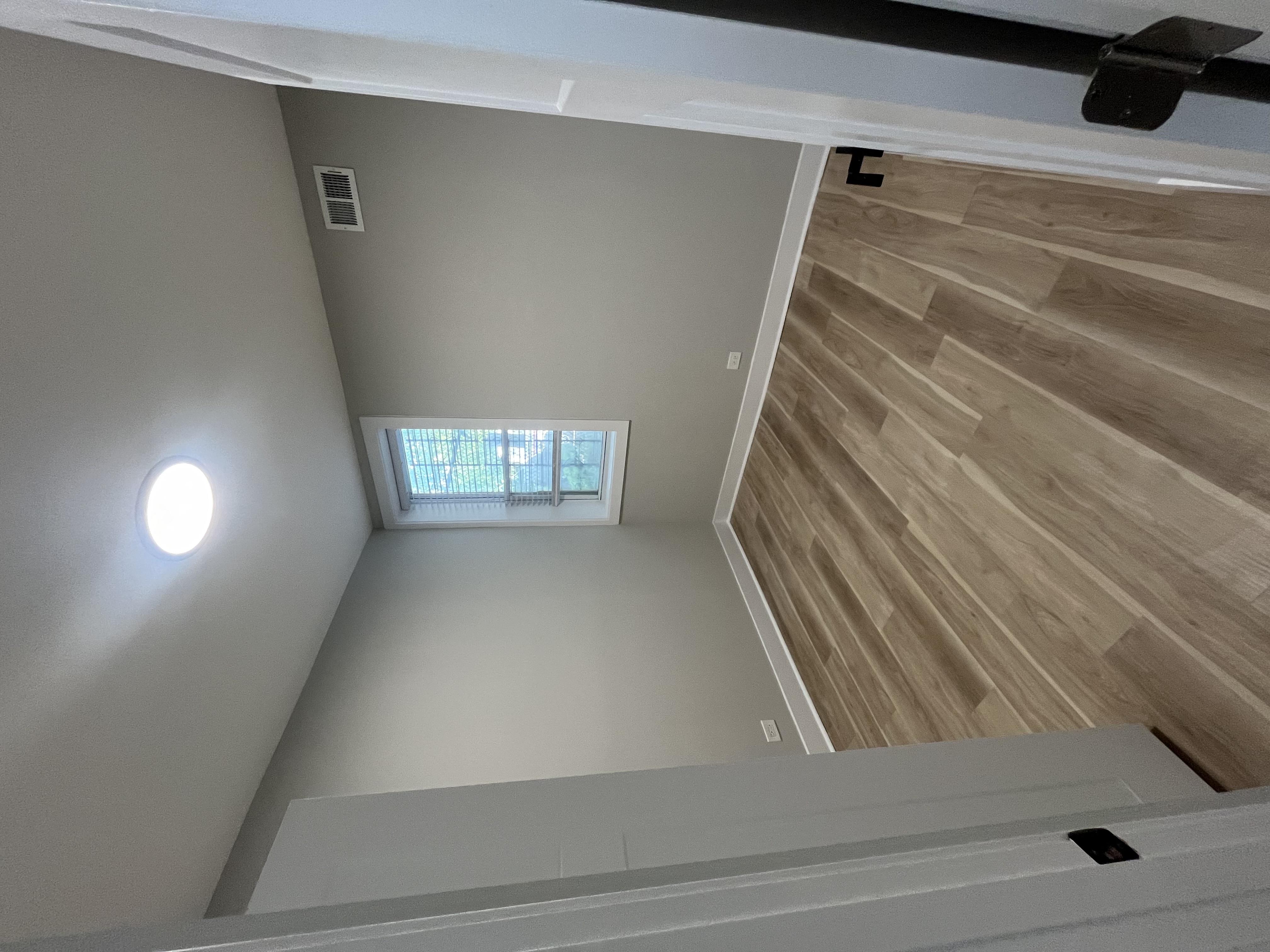 the view from the top of a staircase looking down into a room with wood floors