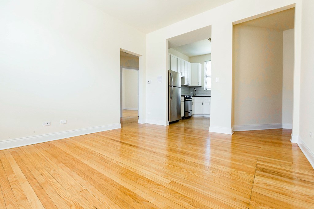 a living room with a hard wood floor and a kitchen