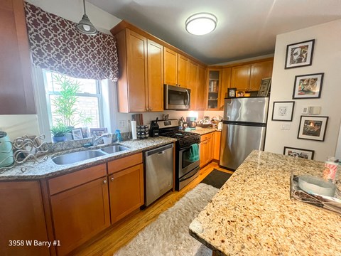 an updated kitchen with stainless steel appliances and granite counter tops