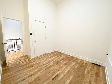 A room with wooden flooring and white walls.