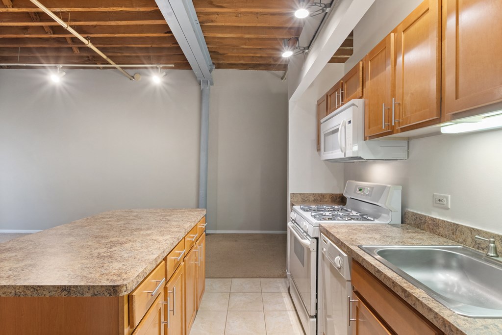 a kitchen with a sink and stove and wooden cabinets
