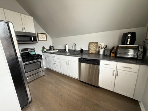 A kitchen with white cabinets and stainless steel appliances.