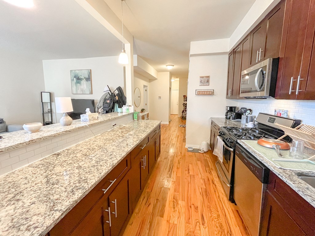 a large kitchen with granite counter tops and wood floors