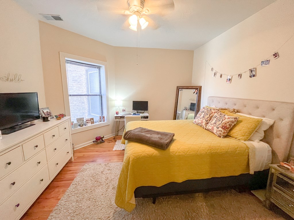 a bedroom with a bed and a dresser and a tv