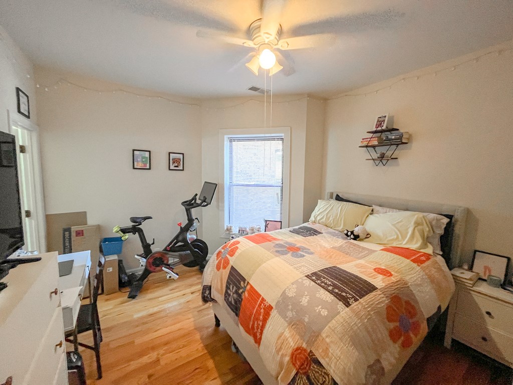 a bedroom with a bed and an exercise bike in the corner