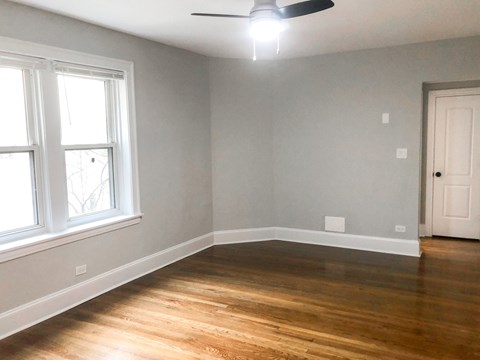 A room with a ceiling fan and a window.