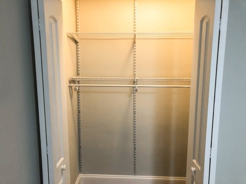 A white refrigerator with empty shelves and drawers.