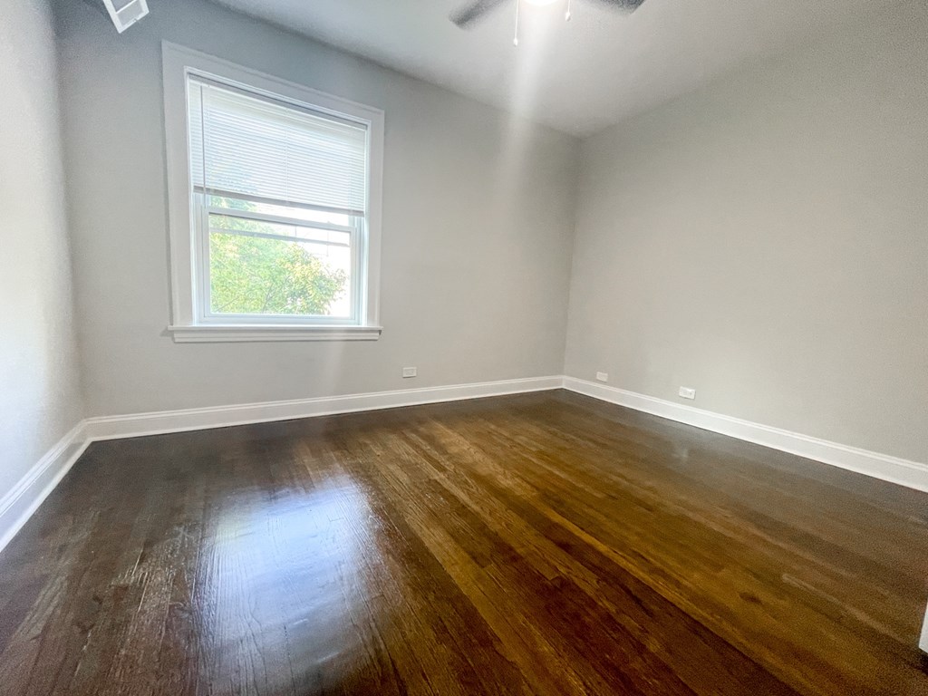 A room with a window and wooden flooring.