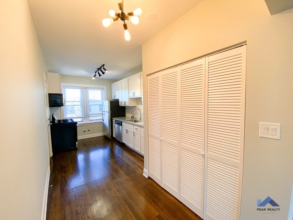 a kitchen with white cabinets and a white ceiling fan