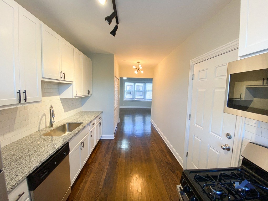 a kitchen with white cabinets and a black stove top oven
