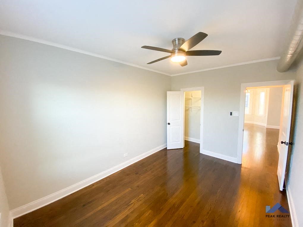 a bedroom with hardwood floors and a ceiling fan