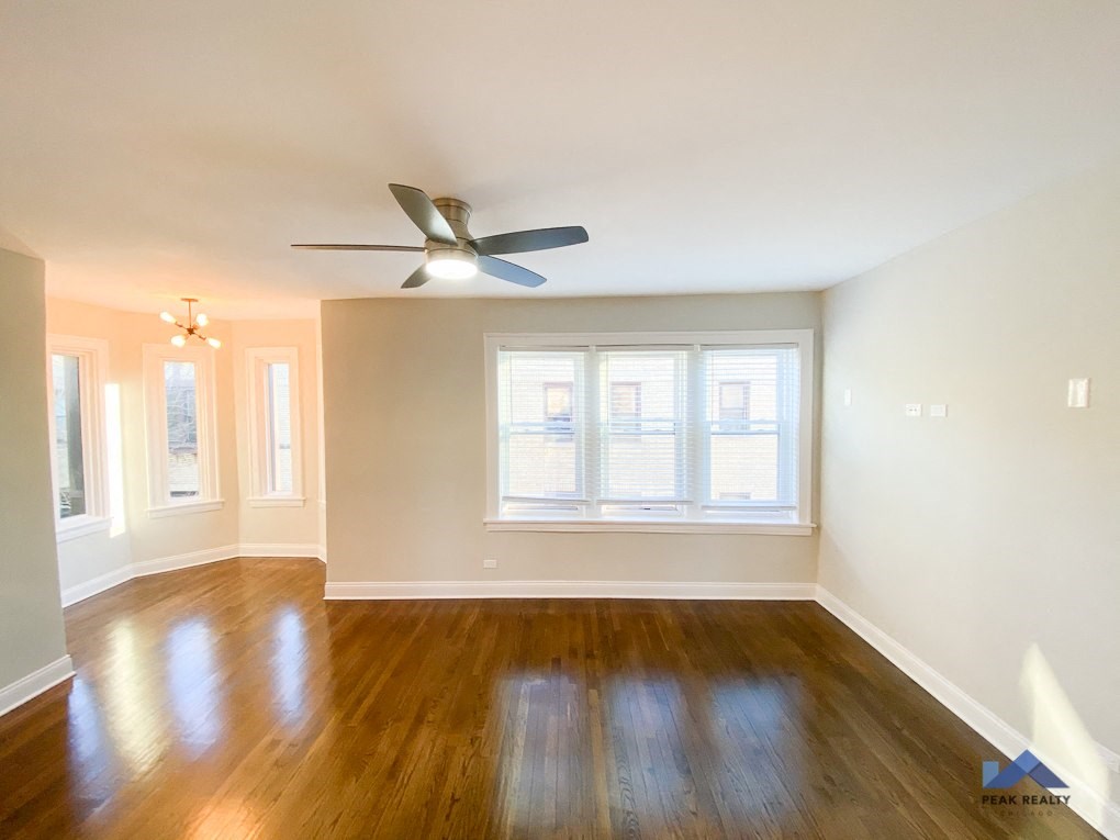an empty living room with a ceiling fan