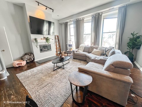 A living room with a couch, coffee table, and fireplace.