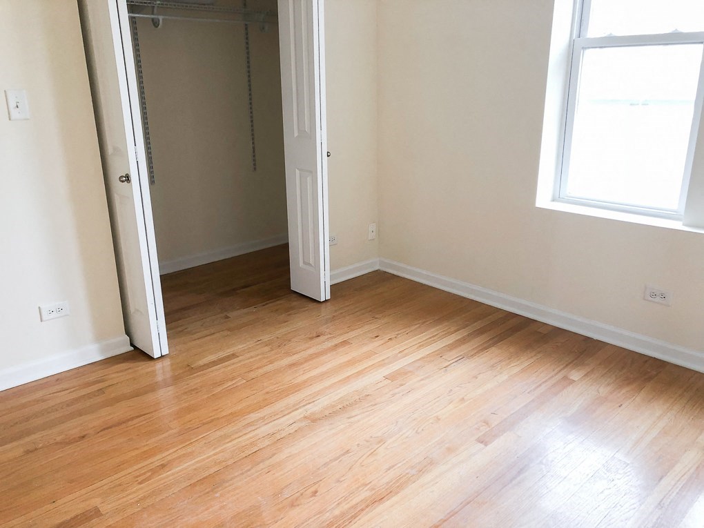 an empty room with wood floors and a closet