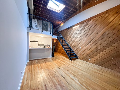 a loft space with wooden floors and walls and a staircase