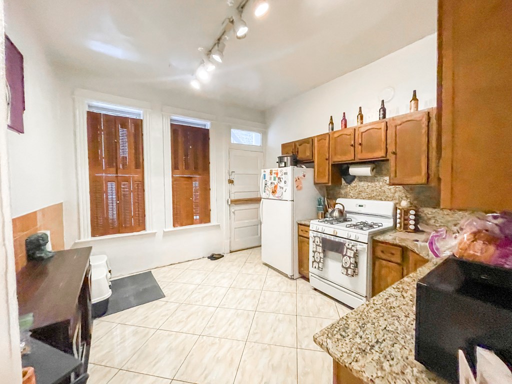 A kitchen with a white refrigerator and wooden cabinets.