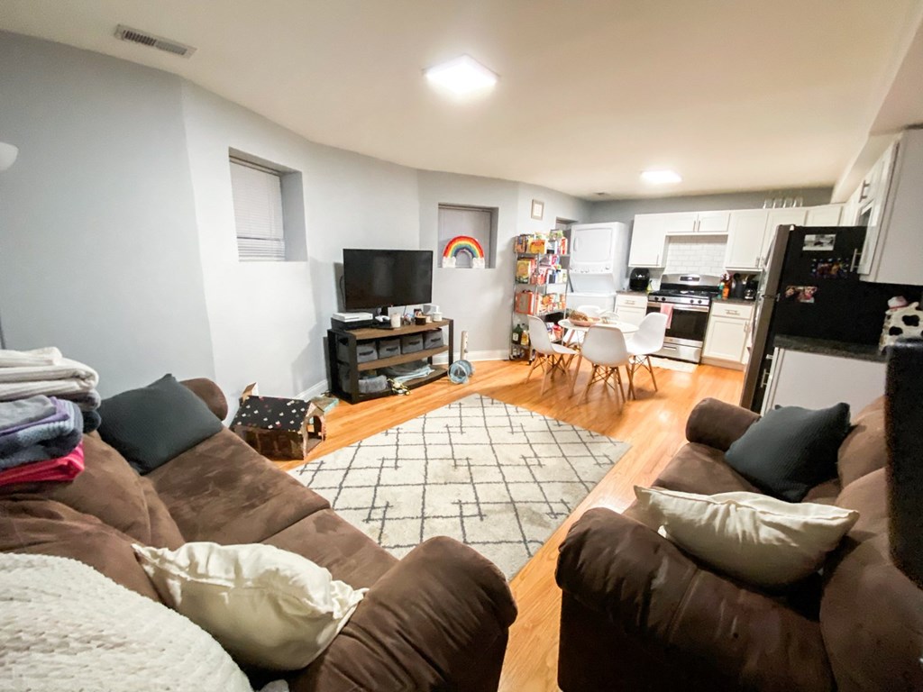 A living room with brown couches and a television.