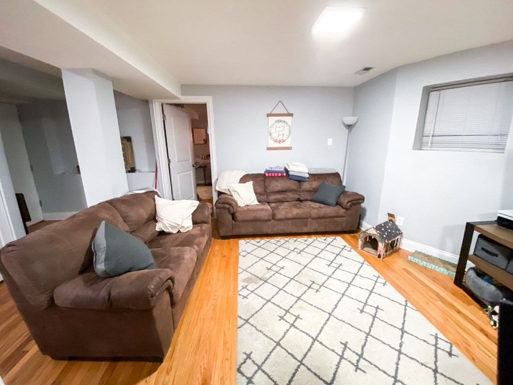 A living room with two brown couches and a rug.