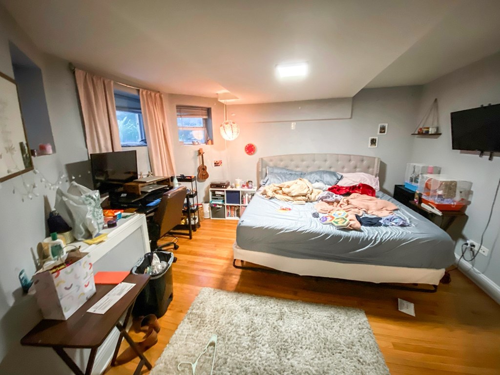 A bedroom with a bed, desk, and chair.