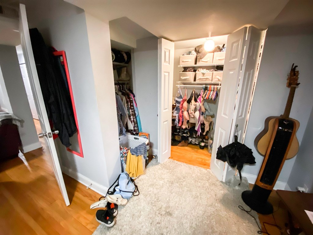 A room with a guitar and a pair of shoes on the floor.
